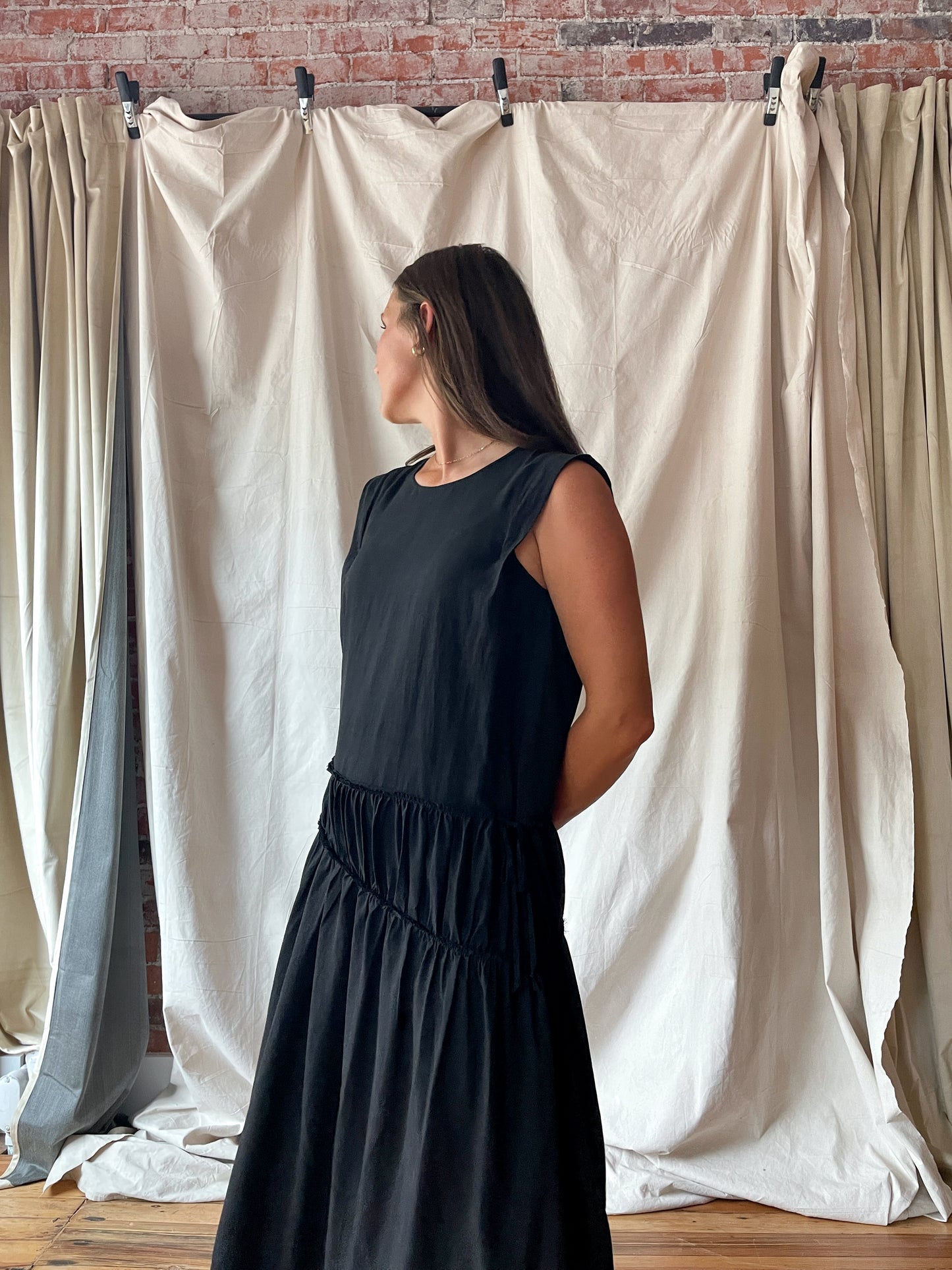Sleeveless black midi dress with cinch detail