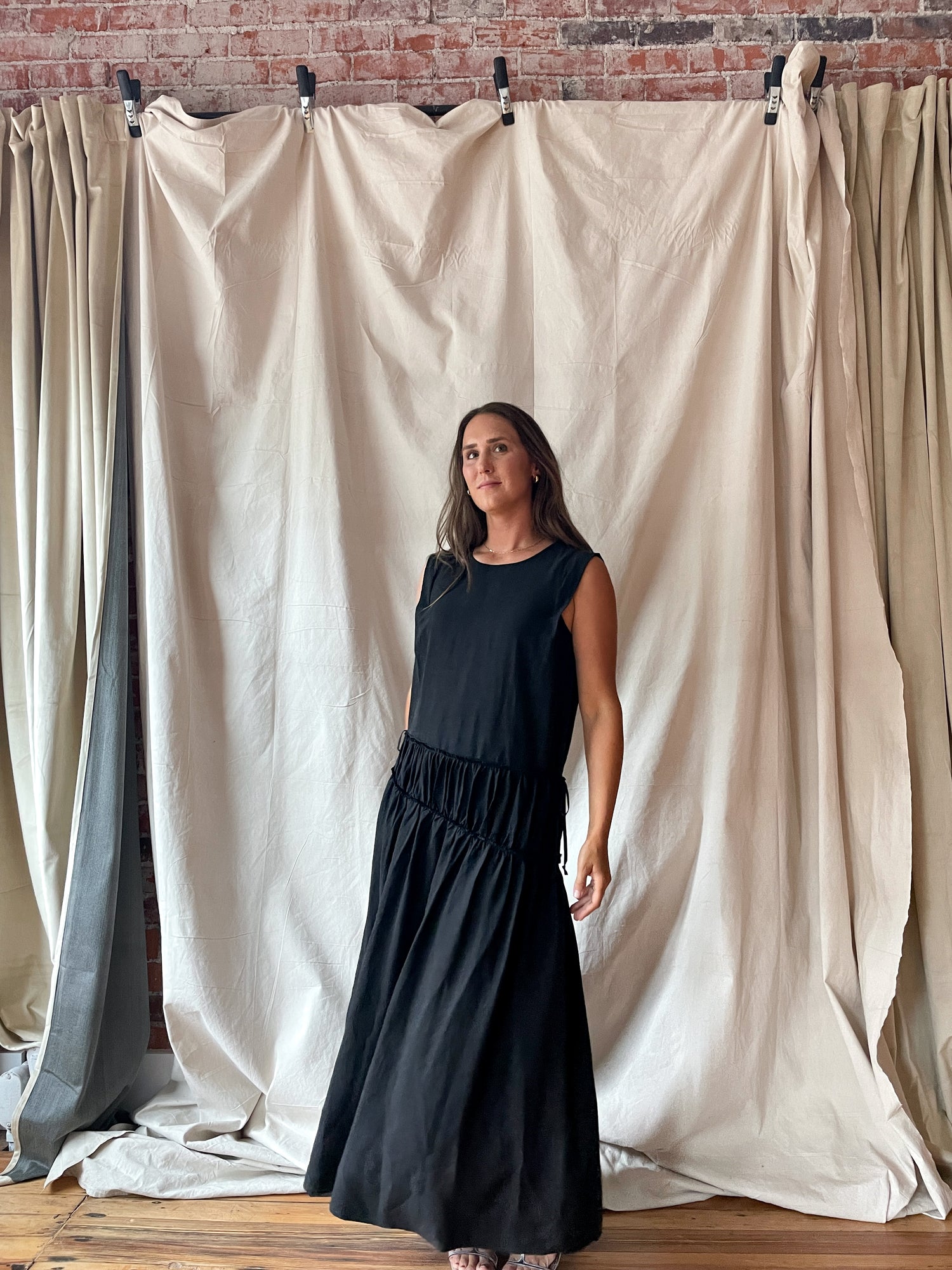 Sleeveless black midi dress with cinch detail