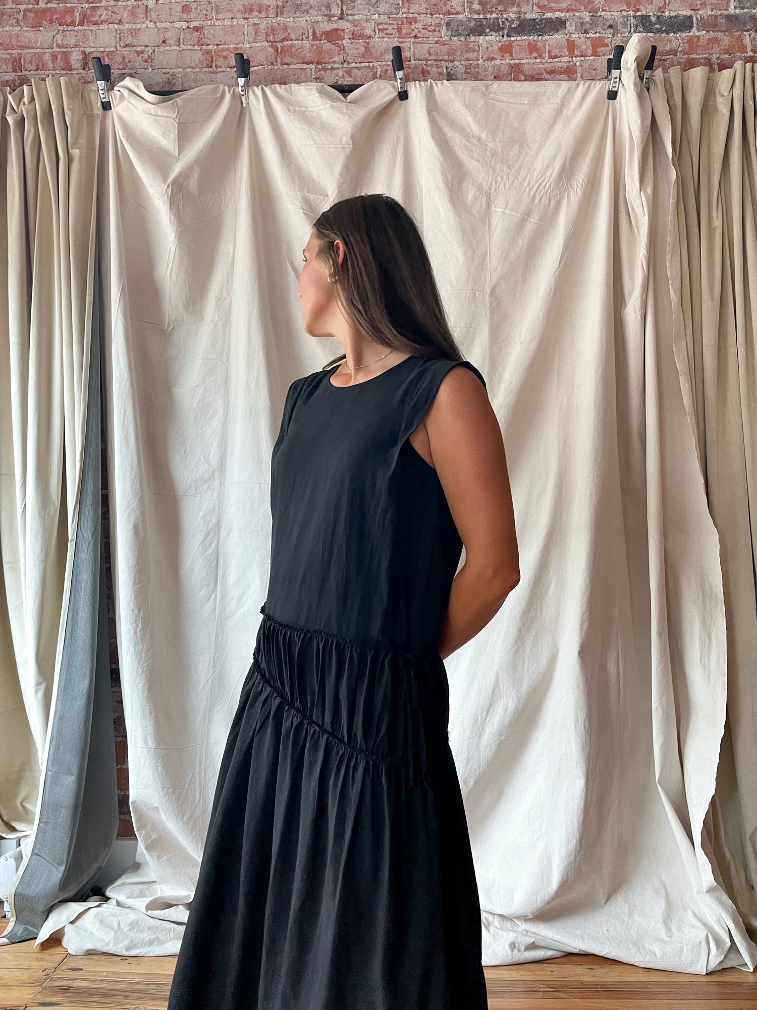 Sleeveless black midi dress with cinch detail